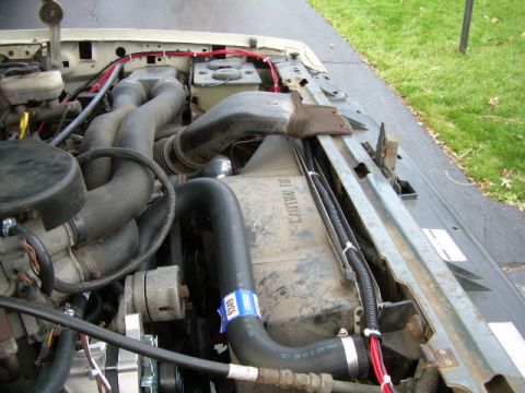 1988 Ford Bronco - Close-up view of the engine bay of a light-colored truck, showing various components and wiring.