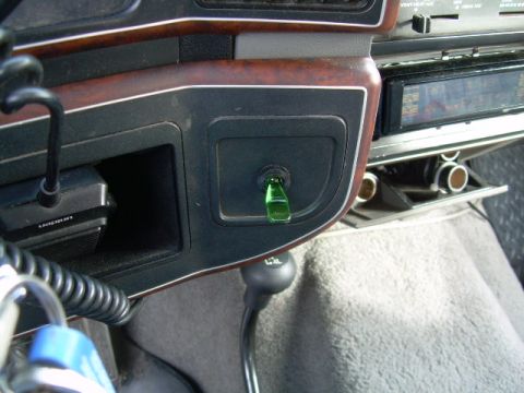 1988 Ford Bronco - Close-up of a vehicle's interior, showing a green toggle switch and gear shift lever.