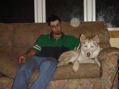 1992 Ford Bronco - Man and husky dog relax on a couch indoors.
