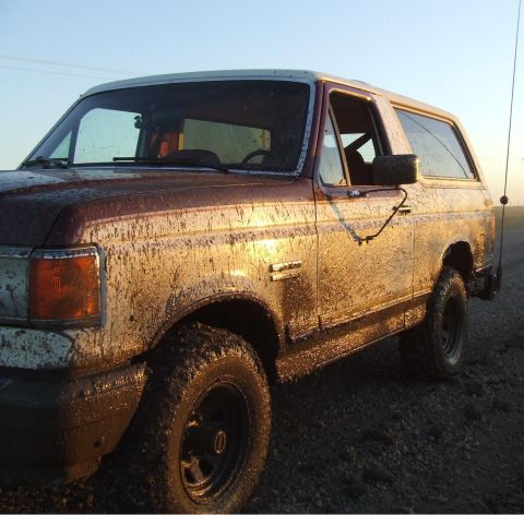 1990 Ford Bronco - This muddy Ford Bronco is covered in dirt and grime, suggesting it has been off-roading.