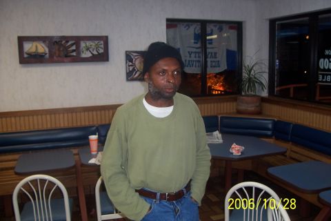 2000 Ford Crown Victoria - Man stands inside a restaurant with booth seating and tables visible.