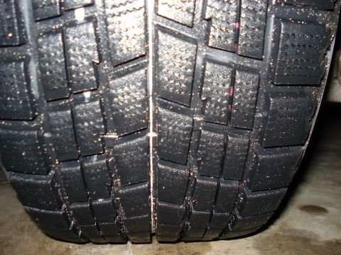 1998 Ford Taurus - A close-up view of a tire's tread, showing its pattern and some dust accumulation.