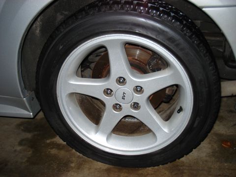 1998 Ford Taurus - A close-up view of a car's wheel, an SVT logo on the center cap.