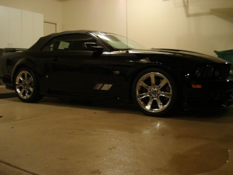 1998 Ford Taurus - Side view of a black convertible with chrome wheels in a garage.