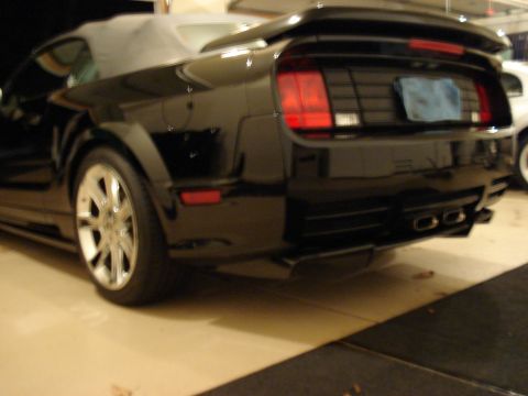 1998 Ford Taurus - Rear view of a black convertible sports car, likely a Ford Mustang from the mid-2000s.