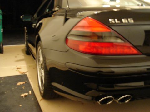 1998 Ford Taurus - Rear view of a black Mercedes-Benz SL65, showing its distinctive taillight and dual exhaust system.