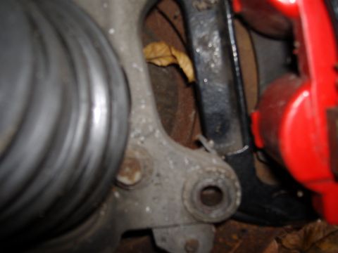 1998 Ford Taurus - A close-up view of a vehicle's suspension system, showing mechanical components and a red brake caliper.