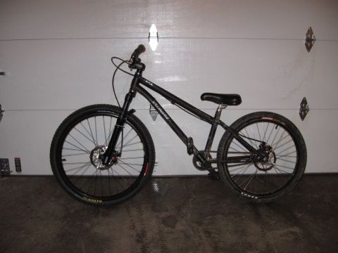 1997 Ford Probe - Black Specialized mountain bike with disc brakes parked in front of a garage door.