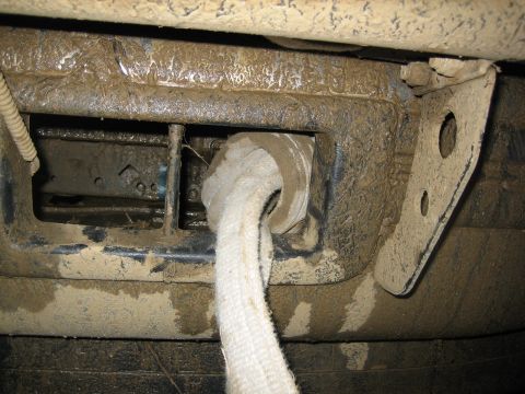1995 Ford Bronco - A close-up view of a muddy tow hook assembly on a vehicle's undercarriage.
