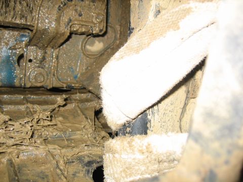 1995 Ford Bronco - Close-up view of a heavily mud-caked vehicle undercarriage, obscuring specific details.
