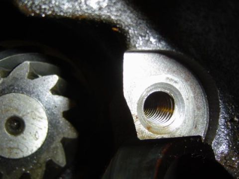 1979 Ford Bronco - Close-up view of a metal gear and a threaded hole, likely part of an engine or transmission.