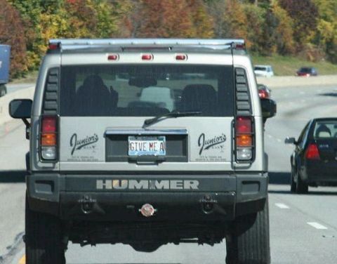 1978 Ford Mustang II - A Hummer H2 drives on the road with a custom license plate and "Junior's" decals on the rear.