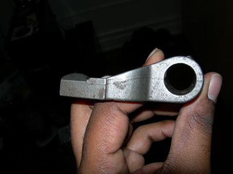 1992 Ford Taurus - A metal automotive part is held for inspection, showing its metallic texture and a central hole.