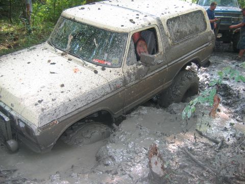 1992 Ford Mustang - A mud-covered 1978 Ford Bronco is stuck in a muddy trail, with another vehicle visible behind it.