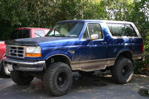 1996 Ford Bronco - Blue 1996 Ford Bronco with lifted suspension and large off-road tires parked outdoors.