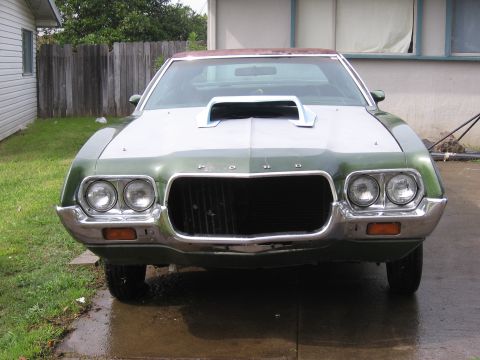 1972 Ford Ranchero - A 1972 Ford Ranchero sits in a driveway, showing its front grille and dual headlights.