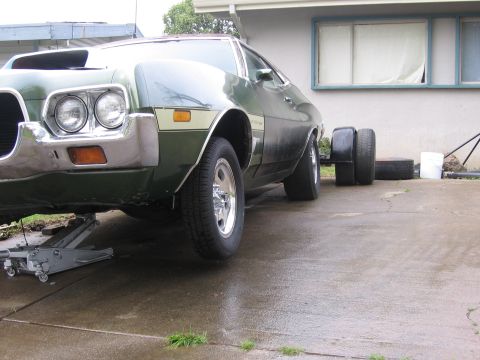 1972 Ford Ranchero - Front end of a 1972 Ford Ranchero is raised by a floor jack, with spare tires nearby.