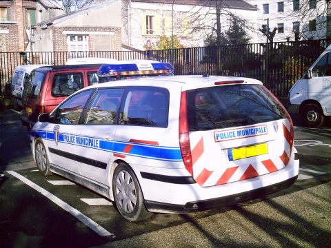 1991 Ford Crown Victoria - A white police car with 'POLICE MUNICIPALE' markings is parked next to other vehicles.