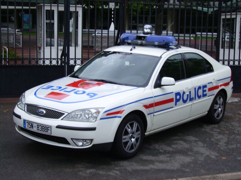White Ford Mondeo police car with blue light bar and 'POLICE' markings