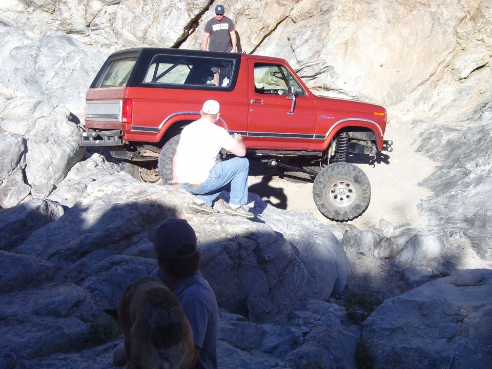 Red 1984 Ford Bronco navigating rocks
