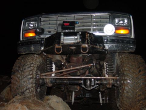 1986 Ford Bronco - This lifted truck features a prominent winch and aggressive off-road tires, viewed from the front.