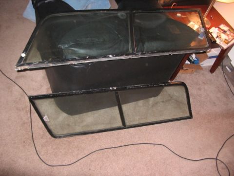 1991 Ford Bronco - Car doors and windows are stacked on a carpeted floor, possibly for storage or repair.