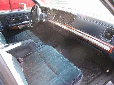 1991 Ford LTD Crown Victoria - The plush velour seats and wood-grain trim are visible inside this vehicle.