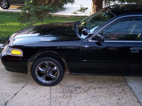 2001 Ford Crown Victoria - A black sedan is shown from the front quarter angle, parked on a concrete driveway.