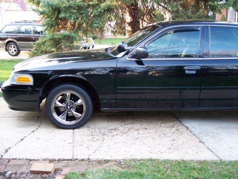 2001 Ford Crown Victoria - Side view of a black 2001 Ford Crown Victoria with aftermarket chrome wheels.