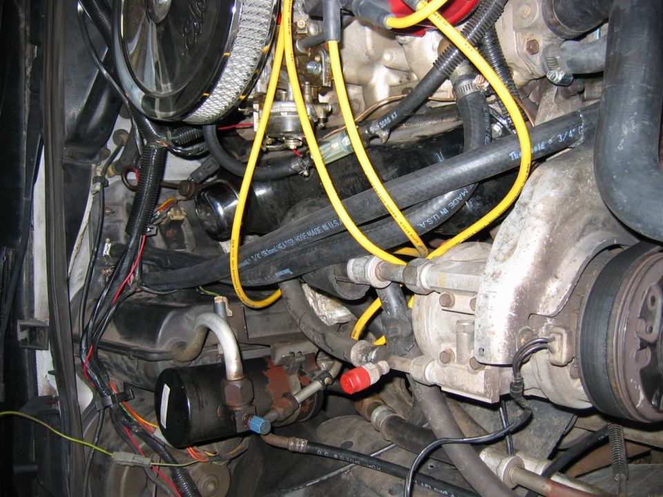 Engine bay with hoses, wires, and air conditioning compressor