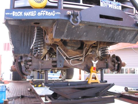 1995 Ford Bronco - Close-up of a lifted Ford Bronco's front suspension, showing extensive rust and modifications.