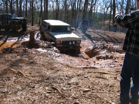 1992 Ford Mustang - A 1978 Ford Bronco is stuck in a muddy off-road trail, with another off-road vehicle visible in the background.