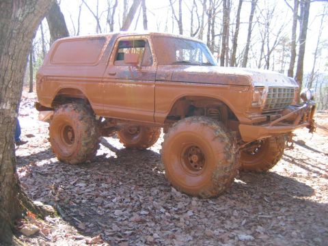 1992 Ford Mustang - Mud-covered 1978 Ford Bronco with large off-road tires on a leaf-covered trail.