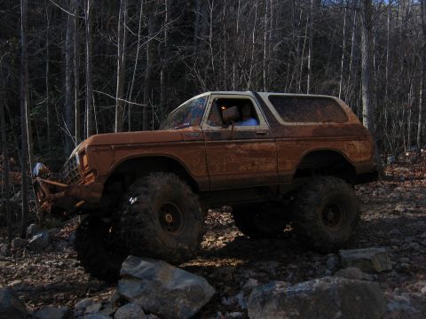 1992 Ford Mustang - This heavily modified 1978 Ford Bronco is shown off-roading through a wooded area.