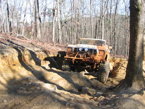 1992 Ford Mustang - Ford F-Series pickup truck tackling a challenging off-road trail in a wooded area.