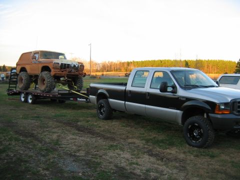 1992 Ford Mustang - A lifted Ford Bronco is transported on a trailer pulled by a Ford F-series pickup truck.