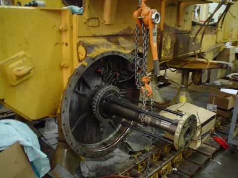 1966 International School Bus - Transmission assembly of heavy machinery undergoing repair, with a hoist and chains attached.