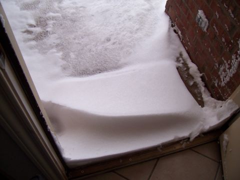 2003 Ford Ranger - A large snowdrift has accumulated in front of a doorway, partially obscuring the entrance.