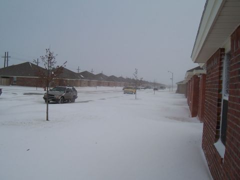 2003 Ford Ranger - A silver SUV is parked on a snow-covered street in a residential area during a winter storm.
