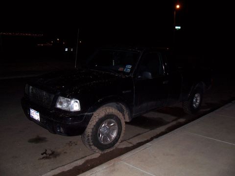 2003 Ford Ranger - This 2003 Ford Ranger pickup truck is parked on a dirt shoulder at night, with mud on the front wheel.