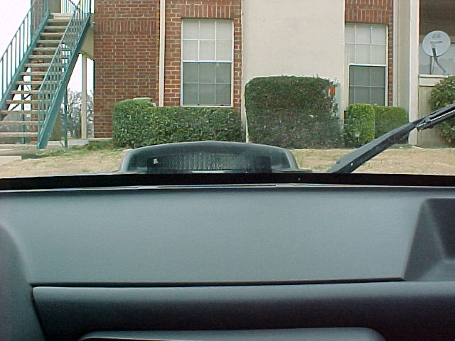 Black hood scoop with ribbed texture, seen from inside a vehicle