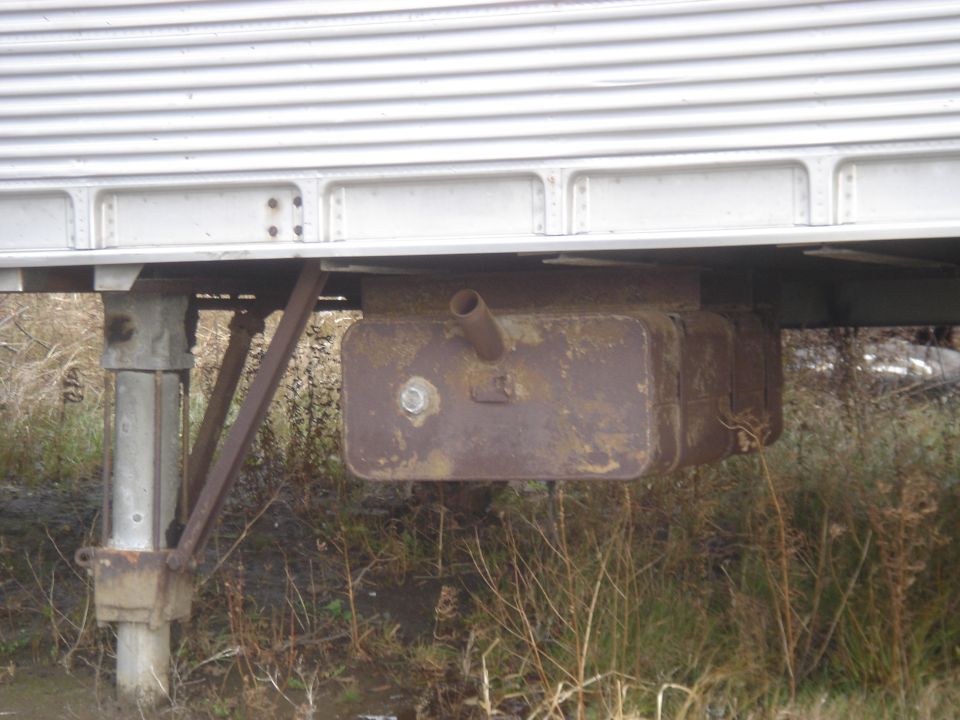 rusty fuel tank mounted under a trailer