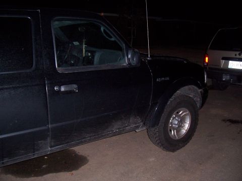2003 Ford Ranger - A black 2003 Ford Ranger pickup truck is parked next to another vehicle at night.