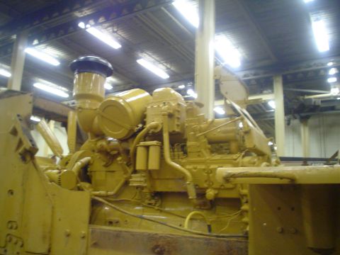 1966 International School Bus - Close-up of a large yellow engine, likely from heavy construction equipment.
