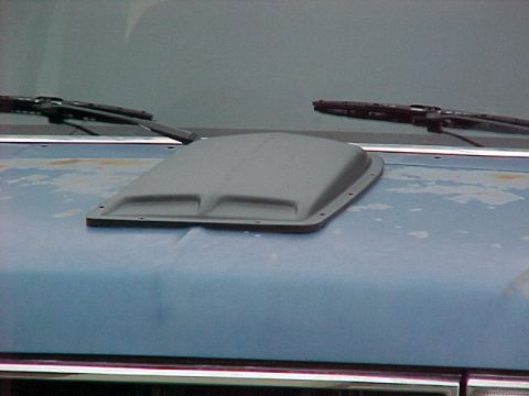1990 Ford Bronco - A gray aftermarket hood scoop is installed on a blue vehicle's hood, obscuring the original vehicle details.