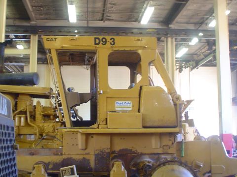 1966 International School Bus - The side view of a yellow Caterpillar D9-3 bulldozer cab shows the CAT logo and model number.