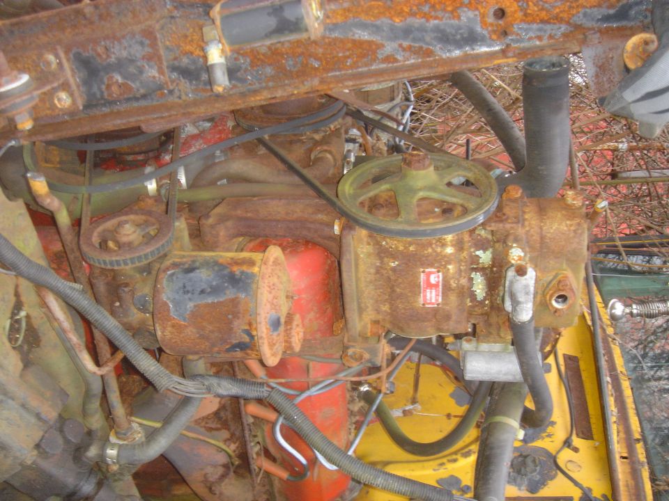 Rusted engine components with yellow and red accents. Watermark reads www.supermotors.net