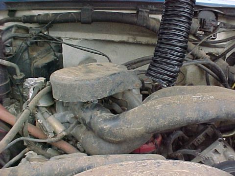 1990 Ford Bronco - Close-up view of an engine bay, focusing on the air intake system and various hoses. Text from a watermark is visible at the bottom right.