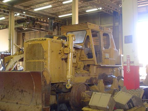 1966 International School Bus - A yellow Caterpillar bulldozer, identified as model D93, is parked indoors, possibly in a workshop or storage area.
