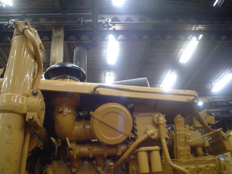Close-up of yellow engine parts including air intake and filters